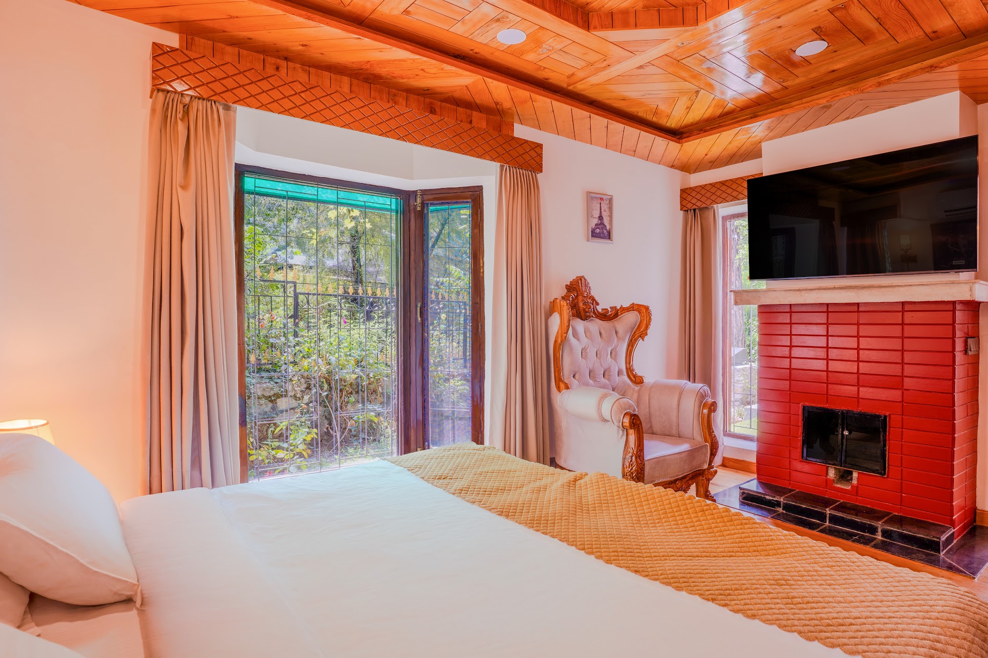 Bedroom with a carved wooden bed in the Premium Courtyard Suite