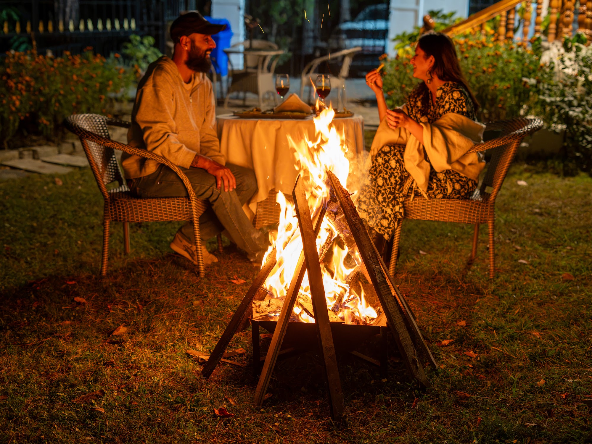 Guests around an evening bonfire in the garden at River Stone Villa